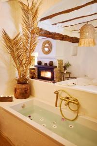 a bath tub in a room with a fireplace at VILASIRA ( Rooms & Wines ) in Los Cojos