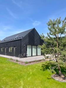a black house with a bike parked in front of it at Seaside Serenity Retreat in Palanga