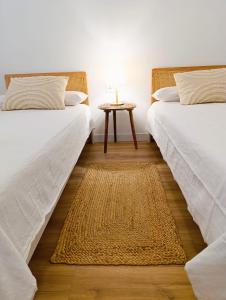 deux lits dans une pièce avec une table entre eux dans l'établissement Casabella Le patio, à Altea