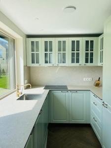 a kitchen with white cabinets and a sink at Seaside Serenity Retreat in Palanga
