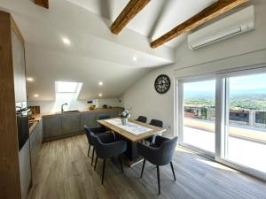 a kitchen and dining room with a table and chairs at Green View Apartment in Vrh