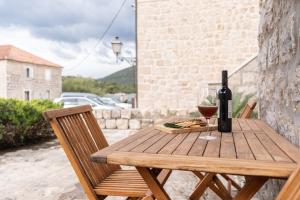 a wooden table with a bottle and a glass of wine at Holiday home Coastal Soul in Mali Ston in Mali Ston