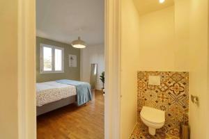 a bedroom with a bed and a toilet in a room at Residence Reine - Boulogne - Paris in Boulogne-Billancourt +11 photos