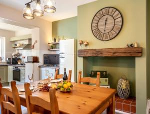 a kitchen with a wooden table and a large clock on the wall at Shorethwaite in Amble +27 photos