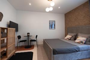 een slaapkamer met een bed en een tafel met een stoel bij Joli studio proche de paris -pantin in Pantin