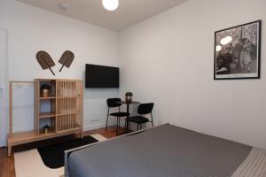 een slaapkamer met een bed en een flatscreen-tv bij Joli studio proche de paris -pantin in Pantin