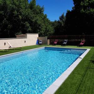 a large swimming pool with chairs in a yard at LAMIELLE grande maison restaurée aux portes du Quercy in Moissac