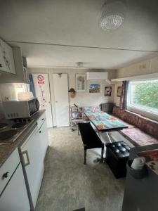 a kitchen and living room with a table in a caravan at Mobilhome situé côté ville et côté campagne in Beaune