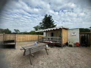 a tiny house with a picnic table and a bench at Mobilhome situé côté ville et côté campagne in Beaune