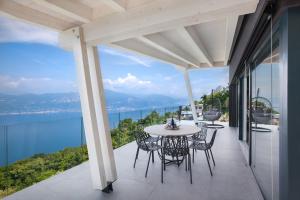 a table and chairs on a balcony with a view of the water at Only Adult Villa Montelago With Pool in Pai