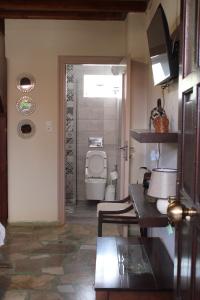 a bathroom with a toilet and a door to a room at Gialova Filoxenia in Gialova