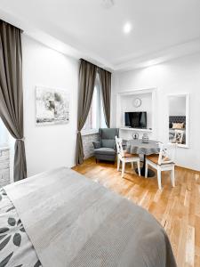 a bedroom with a bed and a table and a couch at City Center Lodge in Pula