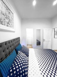 a bedroom with a large bed with blue and white sheets at City Center Lodge in Pula