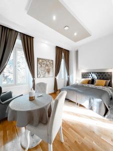 a bedroom with a bed and a table and chairs at City Center Lodge in Pula