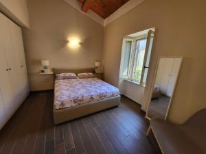 Un dormitorio con una cama y una ventana grande. en Litos, en Bevagna