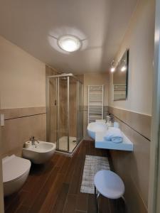 Un baño con dos lavabos y una ducha de cristal. en Litos, en Bevagna 24 fotos más