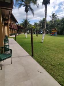einen Park mit einer Bank und einem Spielplatz mit Palmen in der Unterkunft Delta Maresias Club by Smart Sharing in Maresias
