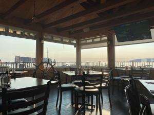a dining room with tables and chairs and windows at Hotel-Motel Fleur de Lys in Perce