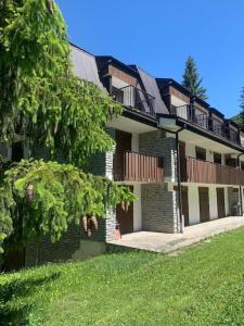 a large building with a grass yard in front of it at Appartamento in mezzo al verde in Sauze dʼOulx