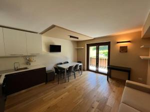 a kitchen and living room with a table and chairs at Appartamento in mezzo al verde in Sauze dʼOulx +26 photos