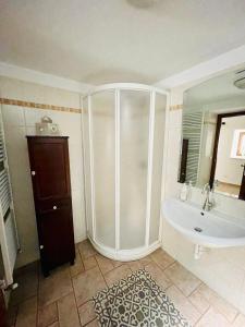 a bathroom with a shower and a tub and a sink at Trulli Ada in Noci