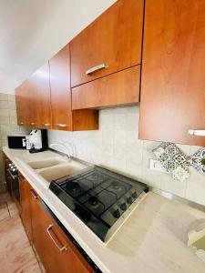 a kitchen with a stove and wooden cabinets at Trulli Ada in Noci +23 photos