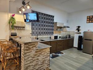 a large kitchen with a counter and a refrigerator at Villa Inaaya - Flic en Flac in Flic-en-Flac