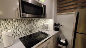 a kitchen with a microwave above a counter with a refrigerator at Charming & Family-Friendly Boqueron Village Condos! in Boqueron