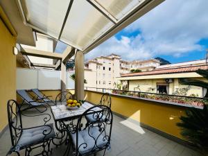 a balcony with chairs and a table with fruit on it at YourHome - Blu Jade House in Piano di Sorrento