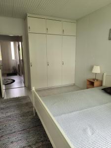 a bedroom with a large bed and white cabinets at Oravamökki in Sotkajärvi