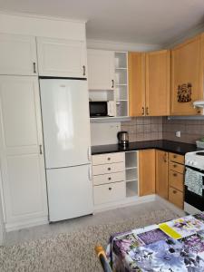 a kitchen with white appliances and wooden cabinets at Oravamökki in Sotkajärvi
