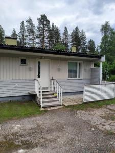 a white house with stairs and a porch at Oravamökki in Sotkajärvi