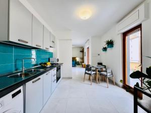 a kitchen with a sink and a table with chairs at YourHome - Blu Jade House in Piano di Sorrento