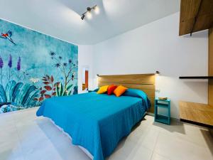a bedroom with a blue bed and a painting on the wall at YourHome - Blu Jade House in Piano di Sorrento