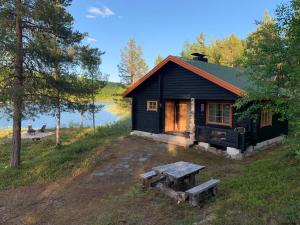 a small cabin with a picnic table in front of it at Villa Aiku in Leppäjärvi