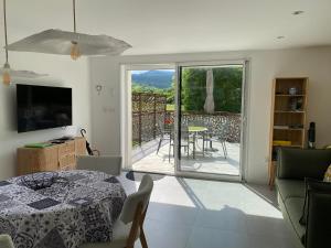 salon ze stołem i widokiem na patio w obiekcie "Luci" proche du Zenith, Arténium Ceyrat, Auvergne, parking privé , w mieście Beaumont