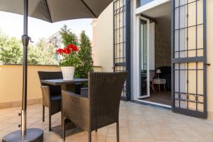 a patio with a table and chairs and an umbrella at Domus Xenia in San Giorgio a Cremano