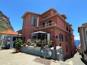 czerwony budynek z restauracją na ulicy w obiekcie Boutique Hotel Jardim Do Mar w mieście Jardim do Mar +16 zdjęć