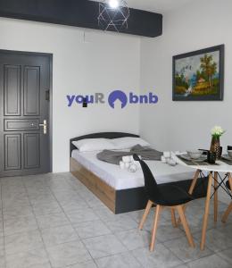 a bedroom with a bed and a table and chairs at Sevi's Home in Komotini