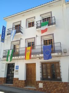 a building with flags on the side of it at Pension La Sierra in Cortes de la Frontera