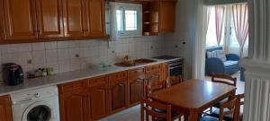 a kitchen with wooden cabinets and a table and a sink at Notoshouse in Nótos