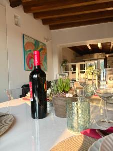 a bottle of wine sitting on a table with glasses at Casa sulle mura Romane - Old town in Bergamo