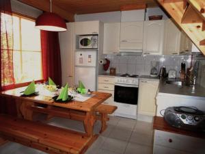 a kitchen with a wooden table with green papers on it at AnriStar in Äkäslompolo +17 photos
