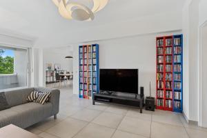 a living room with a flat screen tv and a couch at Central Lux 2BR Apt with City Views & Balcony in Luxembourg