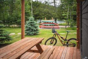 a bike parked on a porch with a picnic table at Condos Kamik Tremblant by Manitonga in Mont-Tremblant