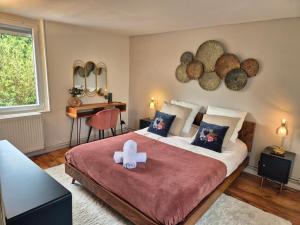 sypialnia z łóżkiem z pluszowym misiem w obiekcie Jacuzzi, Piscine, Station de recharge pour véhicule électrique, Maison normande du 19ème Siècle à 25' de Deauville, classée meublé de tourisme 5 étoiles w mieście Saint-Philbert-des-Champs +39 zdjęć