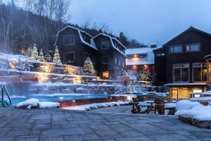 a yard covered in snow next to a house at Tremblant Classic Chalet La Bête Golf Course in Mont-Tremblant
