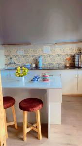a kitchen with a white table and two stools at The apricot house in Leh +24 photos