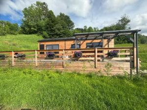 a house with a fence and flowers in a field at Na Rose in Terchová