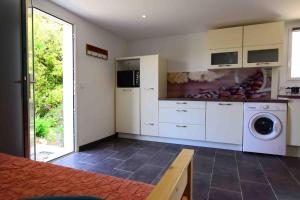 a kitchen with a washer and dryer in a room at Charmant appartement calme, avec terrasse fleurie in Calenzana +13 photos